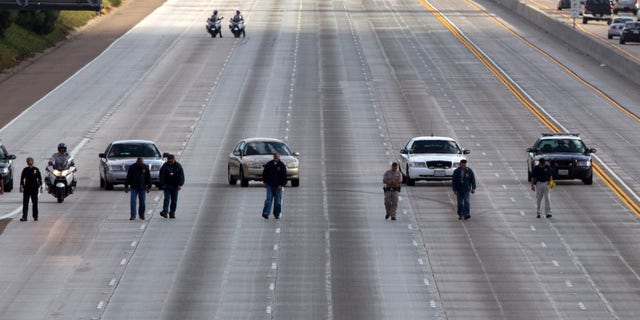 October 3: Law enforcement personal look for evidence on 5 north the 805 and south of Del Mar Heights Road in a string of shootings on Interstates 805 and 5 in Del Mar, California.