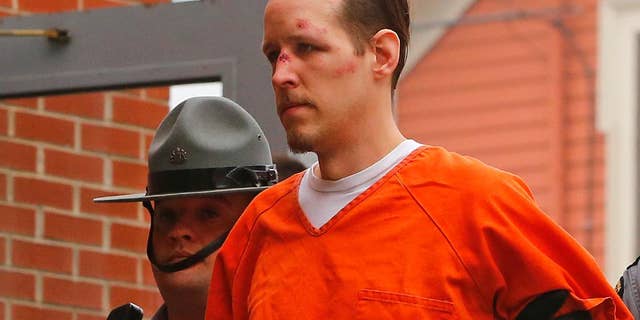 Eric Frein is escorted by police into the Pike County Courthouse for his arraignment in Milford, Pa., Friday Oct. 31, 2014. Frein, was captured seven weeks after police say he killed a Pennsylvania State trooper in an ambush outside a barracks in northeastern Pennsylvania. (AP Photo/Rich Schultz)