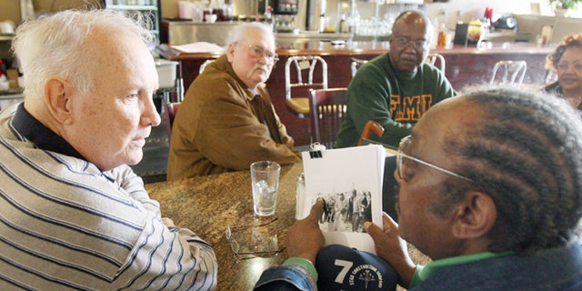 FILE - In this Jan. 23, 2009, file photo, Elwin Wilson, left, and Friendship 9 member Willie McCleod, right, look over pictures from civil rights incidents in Rock Hill, S.C., in the 1960s. The criminal record will soon be erased for the nine black men arrested for integrating a whites-only South Carolina lunch counter 54 years ago. On Wednesday, Jan. 28, 2015, prosecutor is expected to ask a judge to vacate the arrests and convictions of the men known as the Friendship 9. (AP Photo/Herald, Andy Burriss, File)