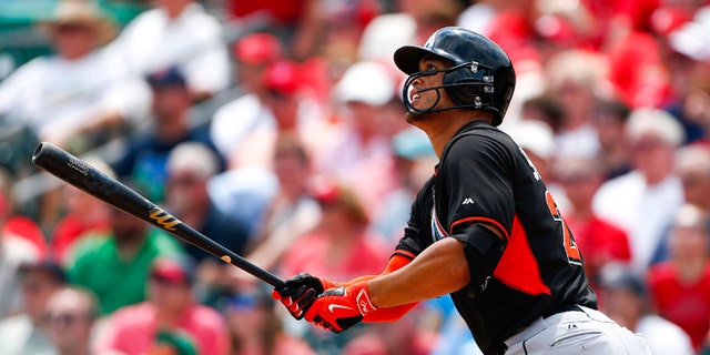 March 26: Miami Marlins' Giancarlo Stanton follows through with a home run in the first inning of an exhibition spring training baseball game against the St. Louis Cardinals.