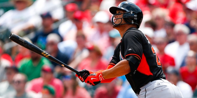March 26: Miami Marlins' Giancarlo Stanton follows through with a home run in the first inning of an exhibition spring training baseball game against the St. Louis Cardinals.