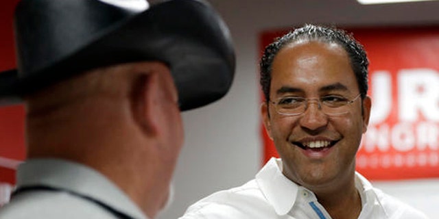 In this Saturday, Aug. 27, 2016 photo, first-term Republican Rep. Will Hurd, right, of Texas, talks with a supporter at a campaign office, in San Antonio. Many House Republican incumbents worry that blowback from Republican presidential nominee Donald Trump's anti-Hispanic rhetoric and promises to build a towering wall the length of the U.S.-Mexico border could hurt their re-election chances, a problem especially acute for those in heavily Latino districts like that of Hurd, whose territory encompasses 820 miles of the U.S.-Mexico border. (AP Photo/Eric Gay)