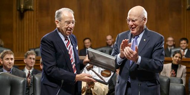 Sen. Patrick Leahy, D-Vt., center, the outgoing chairman of the Senate Judiciary Committee, applauds new committee chairman Sen. Chuck Grassley, R-Iowa, left, on Capitol Hill in Washington, Thursday, Jan. 22, 2015, after presenting Grassley a new gavel as the veteran senators hold an organizational meeting under the new Republican majority. (AP Photo/J. Scott Applewhite)