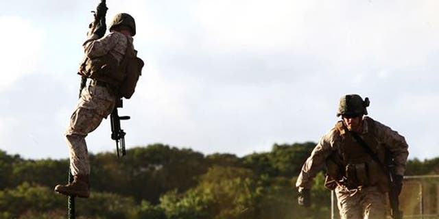 Marines fast-rope out of a helicopter during a training exercise in Guam. (Credit: Lance Cpl. Jenkins/Marine Corps)