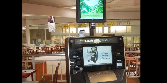 This undated photograph provided by ecoATM, shows the EcoATM, which is a cupboard-sized machine with a big touch screen and a big metal mouth where you can place your old phone or MP3 player. Its analysis complete, it gives you a quote on the spot, based on what a network of hundreds of electronics-recycling companies are willing to pay for it. If you accept, it spits out cash.