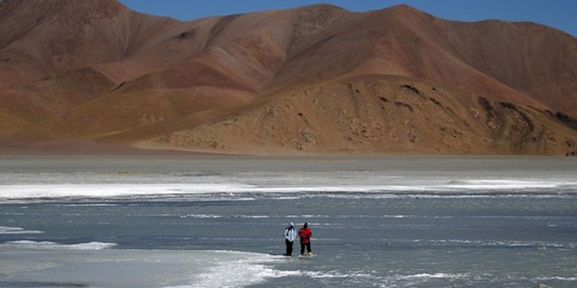 Microbiologist Maria Eugenia Farias (R) and an aide look for rock samples containing bacteria in the crater of the Galan Volcano, at over 15,400 feet above sea level in Catamarca August 4, 2010.