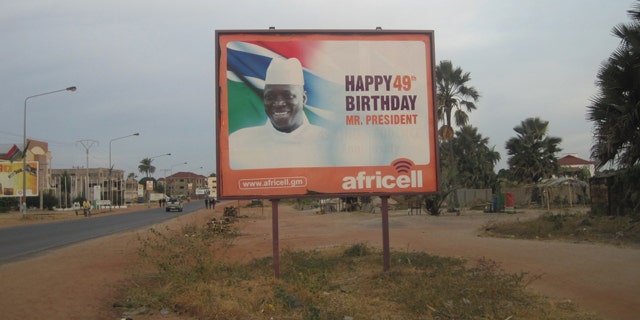 Dec. 31, 2014: A giant billboard of Gambia President Yahya Jammeh sits on an empty street during rush hour in Banjul. Two men have been charged in the United States with conspiring to help overthrow the Gambian government last week. (AP Photo)