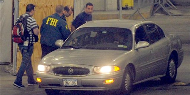 June 2: Richard Palase, standing right, a New York City Police Department detective, was one of 15 people, including two firefighters, who were arrested in connection with a New York City gambling ring, according to federal authorities, in New York. Palase is seen being transferred by FBI agents in the garage of the Jacob K. Javits Federal Building. (AP)