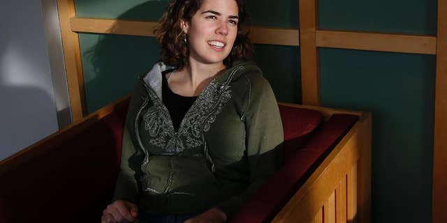 Freshman Lydia Collins, 19, chats with a friend in a lounge at Tufts University in Medford, Mass., Thursday, March 13, 2014. Collins took a year after high school and worked in Ecuador through Global Citizen. Tufts is starting its own program, hoping to remove the financial barriers that keep cash-strapped students from taking a year off after high school to travel or volunteer, and thereby offer an opportunity now typically only available to more affluent students to explore different communities and challenge their comfort zones before starting college. This “gap year” program launching this fall will pay for housing, airfare and even visa fees, which can add up to $30,000 or more. (AP Photo/Elise Amendola)