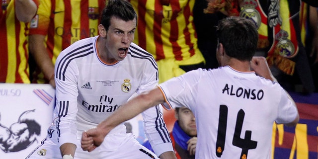 Real's Gareth Bale, left celebrates with Xabi Alonso after scoring his team's 2nd goal during the final of the Copa del Rey between FC Barcelona and Real Madrid at the Mestalla stadium in Valencia, Spain, Wednesday, April 16, 2014. (AP Photo/Alberto Saiz)