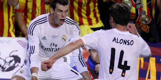 Real's Gareth Bale, left celebrates with Xabi Alonso after scoring his team's 2nd goal during the final of the Copa del Rey between FC Barcelona and Real Madrid at the Mestalla stadium in Valencia, Spain, Wednesday, April 16, 2014. (AP Photo/Alberto Saiz)