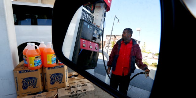 Gas station attendant Youssouf Soukouna, 42, pumps gas into a vehicle at a LukOil station where all levels of gas were priced at $4.99, Wednesday, Sept. 12, 2012, in Newark, N.J. Soukouna, who has worked at the station for 12 years, said he has never seen prices these high. More than 50 LukOil franchise owners plan to raise their prices to more than $8 a gallon on Wednesday to protest what they say is the company's unjustified pricing policies. (AP Photo/Julio Cortez)