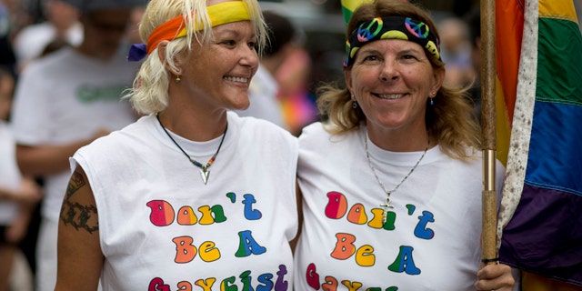 FILE - In this July 2, 2014, file photo, Kimmy Denny and her partner, Barb Lawrence of Palm Harbor, Fla., wait outside a court hearing on gay marriage in Miami. (AP Photo/J Pat Carter, File)
