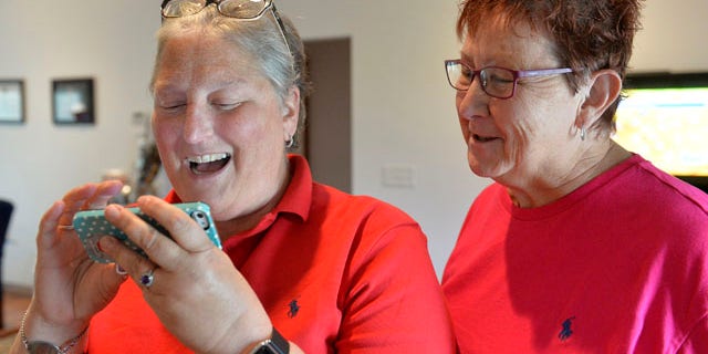 Aug. 26, 2015: April Miller, left, and her partner Karen Roberts read the decision of the United States Sixth Circuit Court of Appeals refusing to hear Rowan County Clerk Kim Davis' appeal that ordering her to issue marriage licenses is against her religious beliefs in Morehead, Ky. (AP Photo/Timothy D. Easley)