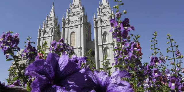 FILE- Sept. 3, 2014: Flowers blooming in front of the Salt Lake Temple in Temple Square, in Salt Lake City. (AP Photo/Rick Bowmer, File)