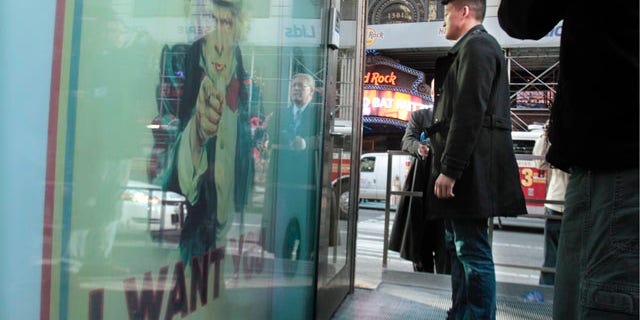 Oct. 19: Dan Choi, center, an Iraq War veteran and a West Point graduate who was discharged from the military in July because he announced publicly that he is gay, stands waiting at the door of the U.S. Armed Forces Recruiting Center in Times Square hoping to re-enlist.
