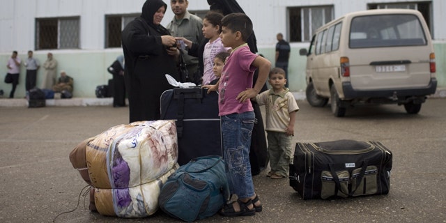May 28, 2011: A Palestinian family waits before crossing into Egypt through the Rafah border crossing, southern Gaza Strip. After four years, Egypt on Saturday permanently opened the Gaza Strip's main gateway to the outside world, bringing long-awaited relief to the territory's Palestinian population and a significant achievement for the area's ruling Hamas militant group.