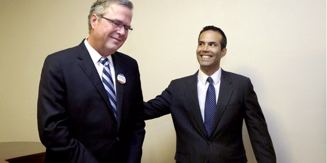 File - In this Oct. 4, 2014 file photo, George P. Bush, right, reaches to his father former Florida Gov. Jeb Bush after the senior Bush became emotional when expressing his pride for his son while speaking to supporters at Hardin-Simmons University, in Abilene, Texas. George P. Bush has been helping members of his famous family get elected since age 3 but has never played a larger role as a political surrogate than this cycle, as he tries to help his dad follow his grandfather, George H.W. Bush, and his uncle, George W. Bush, to the White House. (AP Photo/LM Otero, File)