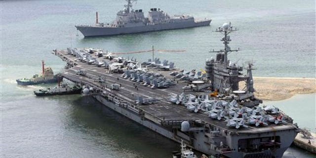 July 21: The massive USS George Washington aircraft carrier is escorted into the Busan port in South Korea for joint military exercises.
