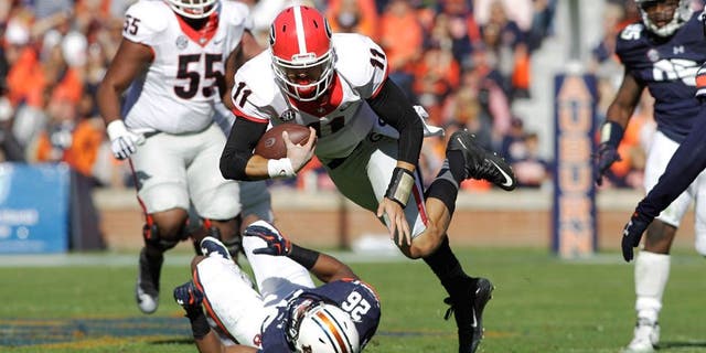Nov 14, 2015; Auburn, AL, USA; Georgia Bulldogs quarterback Greyson Lambert (11) stumbles past Auburn Tigers corner back Devin Gillespie (26) during the third quarter at Jordan Hare Stadium. The Bulldogs beat the Tigers 20-13. Mandatory Credit: John Reed-USA TODAY Sports