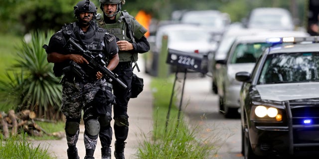 Dekalb County Police SWAT officers run toward Ronald E. McNair Discovery Learning Academy after reports of a gunman entered the school, Tuesday, Aug. 20, 2013, in Decatur, Ga. Superintendent Michael Thurmond says all students at Ronald E. McNair Discovery Learning Academy in Decatur east of Atlanta are accounted for and safe Tuesday and that he is not aware of any injuries. (AP Photo/David Goldman)