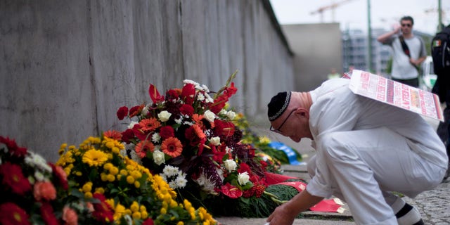 Achim von Almrich lights a candle at the Berlin Wall Memorial at Bernauer Strasse in Berlin, Saturday, Aug. 13, 2011.