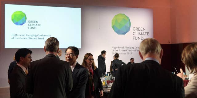 Delegates and participants of the Green Climate Fund talk to each other prior the meeting in Berlin, Germany, Thursday Nov. 20, 2014. A United Nations fund that will help poor countries tackle climate change has fallen short for now of its target of collecting US $10 billion, officials said Thursday. Some 30 countries meeting in Berlin pledged a total of $9.3 billion toward the Green Climate Fund. (AP Photo/dpa,Rainer Jensen)