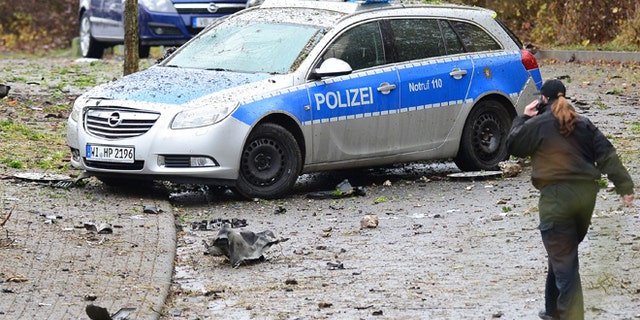 Nov. 16, 2014: A police woman passes a destroyed police car near Homberg Germany. (AP/dpa,Boris Roessler)