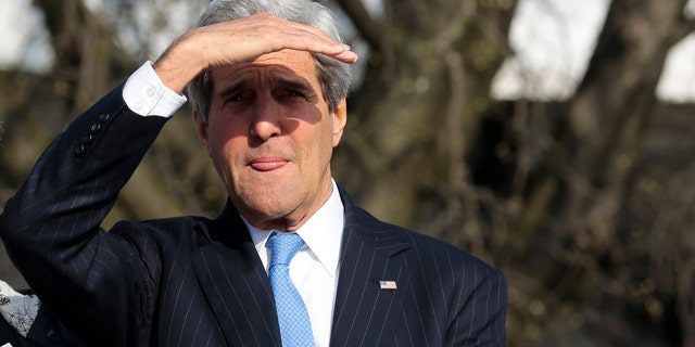 April 15, 2015: United States Secretary of State John Kerry shields his eyes against the sun as he uses a boat on his way to a working session during a meeting of the G7 Foreign Ministers in Luebeck, Germany. The meeting is being held ahead of the G7 leaders summit in Germany from June 7 to 8, 2015. (AP Photo/Markus Schreiber)