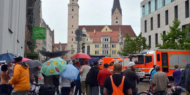 Aug. 19, 2013 - Onlookers stand in front of city hall in Ingolstadt, Germany, after a man took several hostages. Police spokesman Guenther Beck said it wasn't clear what weapons the man might have or what he wants.