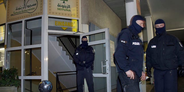 Nov. 26, 2015: Masked police officers guard the 'Seituna' cultural center in Berlin, Germany. Police raided the mosque after the arrest of two people suspected of belonging to an Islamist extremist group. (AP Photo/Michael Sohn)
