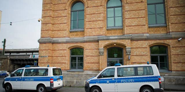 Police cars park in front of the police station at the railway station in Hannover, Germany, Monday, May 18, 2015. Hannover prosecutors said a 39-year-old police officer is being investigated on allegations he abused two immigrants while they were in custody and boasted about it over social media. (Julian Stratenschultedpa via AP)