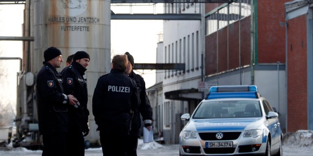 Jan. 5, 2011: In this picture, police stand in front of an animal feed products company in Uetersen, northern Germany that was searched and temporarily closed by authorities. German authorities have stopped more than 4,700 farms from selling their meat and eggs as a precautionary measure against a growing scandal over animal feed contaminated with cancer-causing chemicals that is also affecting exports. Authorities believe some 150,000 tons of feed for poultry and swine containing industrial fat have been fed to livestock across Germany. The fat contains dioxins and should not have been in the food.
