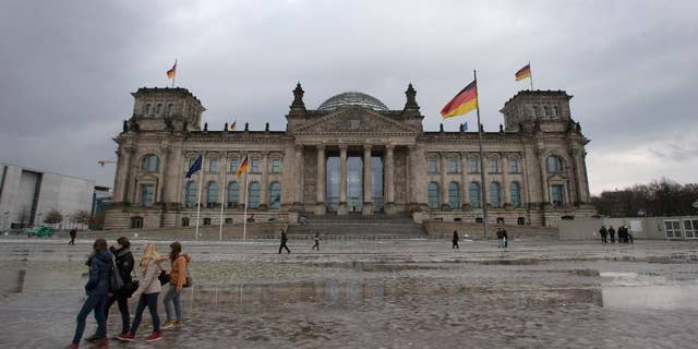 FILE - In this Jan. 29, 2013, file photo visitors walk past the Reichstag building, host of the German federal parliament Bundestag, in Berlin Germany. Berlin police say an unidentified person threw a Molotov cocktail onto the steps of the capital's landmark Reichstag but failed to start a blaze. The person threw the bottle full of a flammable liquid at a side entrance of the building early Monday morning, Sept. 29, 2014, police said. They say the liquid ignited for a short time and then sputtered out, and the attacker fled on foot. Nobody was injured. (AP Photo/Michael Sohn, File)