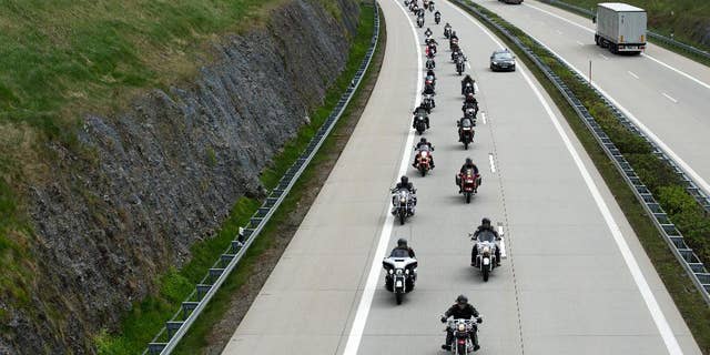 Members of the Russian motorcycle club 'Night wolves' as well as supporters ride their motorbikes along a motorway near Breitenau, Germany, May 7,2015. They are expected to arrive in Berlin on May 9, as part of their tour from Moscow to the German capital. Russia will celebrate the anniversary of the Soviet Union's World War II victory over Nazi Germany on the same day. ( Arno Burgi/dpa via AP)