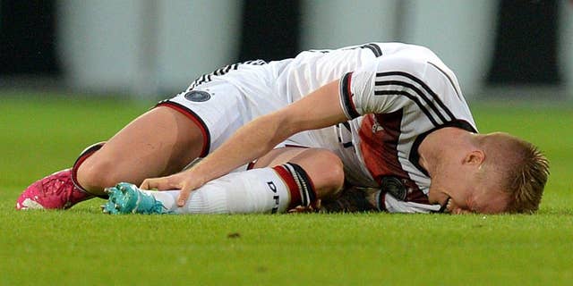 In this picture taken Friday June 6, 2014 German national soccer player Marco Reus lies on the pitch during the friendly soccer match between Germany and Armenia in Mainz Germany. Reus was helped off the pitch after twisting his left ankle while challenging Artur Yedigaryan for the ball. Reus immediately dropped to the grass and appeared in considerable pain. Team doctor Hans-Wilhelm Mueller-Wohlfahrt shook his head as he assisted the Borussia Dortmund player off the pitch. Reus was taken to the hospital to determine the full extent of the injury. AP Photo/dpa,Thomas Eisenhuth)
