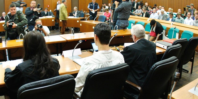 Aug. 31, 2011: 21-year old Arid Uka, center, photographed from behind, waits for the beginning of his trial at a court in Frankfurt, Germany.