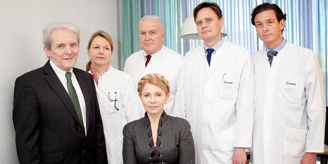 In this picture publicly provided by the Charite hospital in Berlin, former Ukrainian Prime Minister Yulia Tymoshenko , center,  poses  with her doctors  Professor  Karl Max Einhaeupl , left,  CEO of the Charite Hospital and doctors from left :  Dr. Anett Reisshauer , Professor  Nobert Haas, Professor Matthias Endres, and Professor Peter Vajkoczy in the Charite Hospital in Berlin, Germany,  on Saturday March 8,  2014.  Ukraine's former prime minister, Yulia Tymoshenko, has started medical treatment at Berlin's Charite hospital after arriving late Friday, but doctors treating her say it's too soon to say how long this will take. (AP Photo/ho/Charite Universitaetsmedizin Berlin) MANDATORY CREDIT