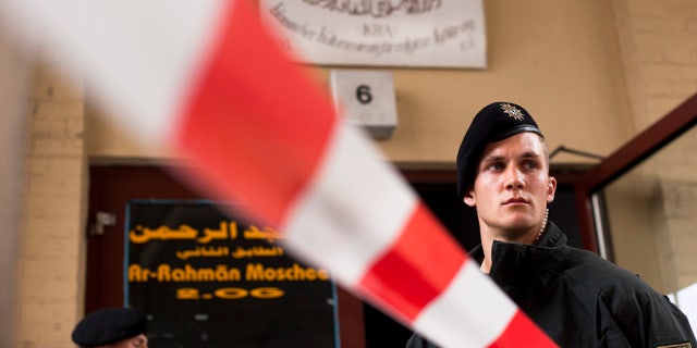 Sept. 8: A German police officers stand guard outside an Islamic cultural center as others conduct a search, in Berlin.