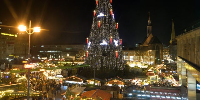 Germany's biggest Christmas tree shines in the center of a Christmas market in Dortmund, Germany, Dec. 13, 2013.