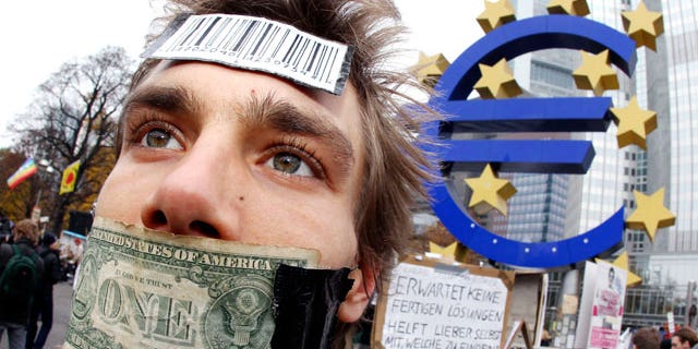 Nov. 12, 2011: A demonstrator has taped his mouth with a dollar bill in front of the European Central Bank in Frankfurt, Germany.