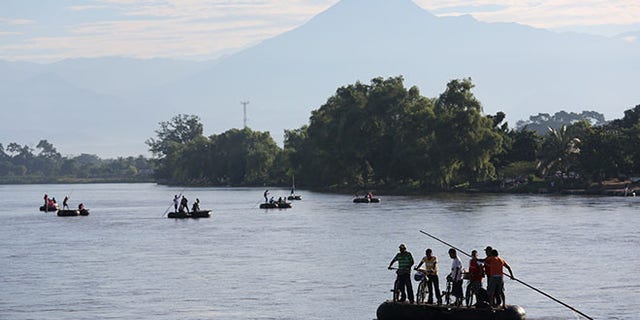 People cross the Suchiate River on rafts from Guatemala into Mexico on August 2, 2013 in Ciudad Hidalgo, Chiapas, Mexico.