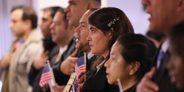 NEWARK, NJ - NOVEMBER 20: Immigrants take oath of citizenship to the United States on November 20, 2014 in Newark, New Jersey. Sixty immigrants from 25 countries became American citizens during the naturalization ceremony at the U.S. Immigration and Citizenship Services (USCIS) office at Newark's Federal Building. (Photo by John Moore/Getty Images)