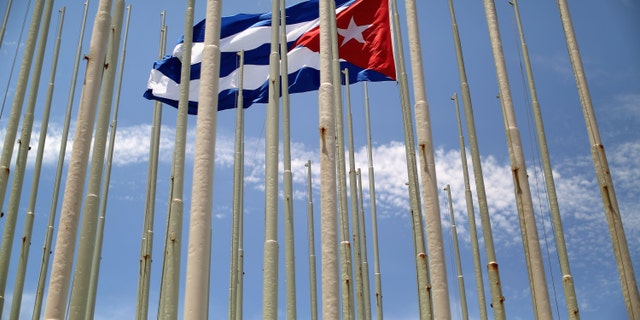HAVANA, CUBA - AUGUST 13: A lone Cuban flag is raised inside the 'Wall of Flags' across the street from the U.S. Embassy August 13, 2015 in Havana, Cuba. Cuba planted 138 flag poles in February 2006 in an attempt to obsucre an electronic message ticker on the outside of the U.S. Interests Section building. U.S. Secretary of State John Kerry will visit Havana Friday and raise the American flag at the reopened U.S. embassy, a symbolic act after the the two former Cold War enemies reestablished diplomatic relations in July. (Photo by Chip Somodevilla/Getty Images)