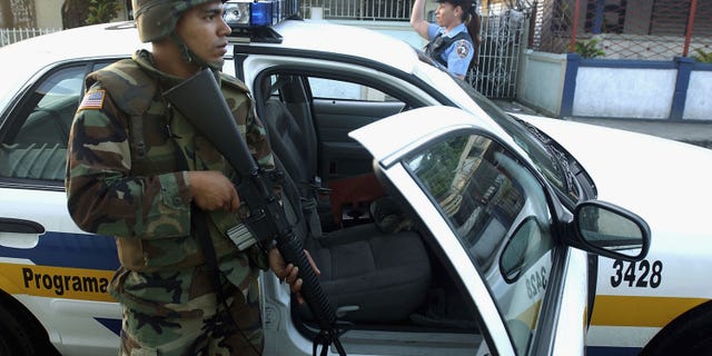SAN JUAN, PUERTO RICO - JULY 23: U.S. Army Specialist Michael Montijo joins Puerto Rico Police Department officers on an early morning patrol July 23, 2004 in San Juan, Puerto Rico. Puerto Rico Governor Sila Maria Calderon activated 500 National Guardsmen to try to bring stability after a crime wave swept the island. (Photo by Jose Jimenez/Getty Images)