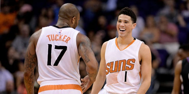 PHOENIX, AZ - APRIL 13:  Devin Booker #1 of the Phoenix Suns smiles in front of teammate P.J. Tucker #17 in the first half of the NBA game against the Los Angeles Clippers at Talking Stick Resort Arena on April 13, 2016 in Phoenix, Arizona.  The Los Angeles Clippers won 114 - 105.  NOTE TO USER: User expressly acknowledges and agrees that, by downloading and or using this photograph, User is consenting to the terms and conditions of the Getty Images License Agreement. (Photo by Jennifer Stewart/Getty Images)