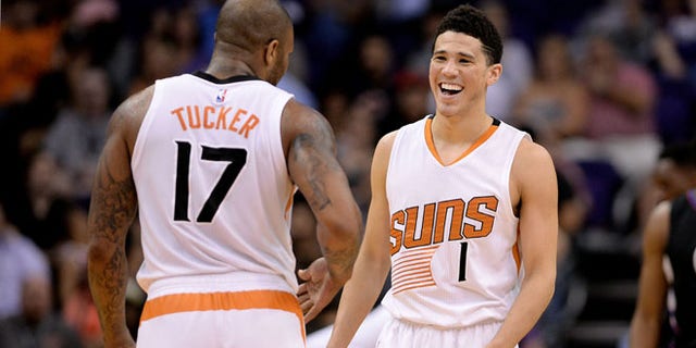 PHOENIX, AZ - APRIL 13: Devin Booker #1 of the Phoenix Suns smiles in front of teammate P.J. Tucker #17 in the first half of the NBA game against the Los Angeles Clippers at Talking Stick Resort Arena on April 13, 2016 in Phoenix, Arizona. The Los Angeles Clippers won 114 - 105. NOTE TO USER: User expressly acknowledges and agrees that, by downloading and or using this photograph, User is consenting to the terms and conditions of the Getty Images License Agreement. (Photo by Jennifer Stewart/Getty Images)