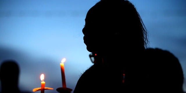 BATON ROUGE, LA - JULY 18: Mourners attend a candlelight vigil honoring Officer Matthew Gerald on July 18, 2016 in Baton Rouge, Louisiana. Officer Gerald, along with two other police officers, was shot and killed after gunman Gavin Long ambushed them on Sunday morning in front of the B-Quik gas station in Baton Rouge.(Photo by Sean Gardner/Getty Images)