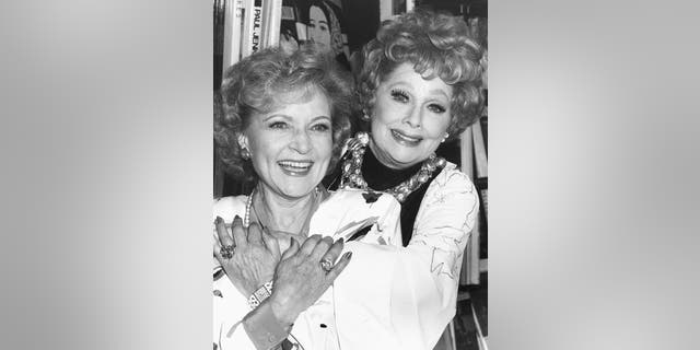 Actresses Betty White (left) and Lucille Ball are shown embracing at a book signing event in Los Angeles, in October 1987.