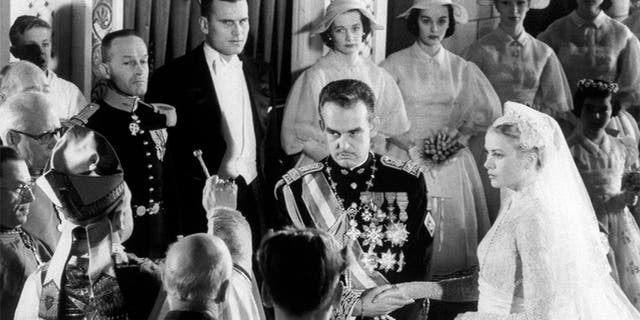 Prince Rainier of Monaco and actress Grace Kelly join hands as Bishop of Monte Carlo Mgr. Gilles Barthe gives them nuptial benediction, during their wedding ceremony at Saint Nicholas Cathedral.